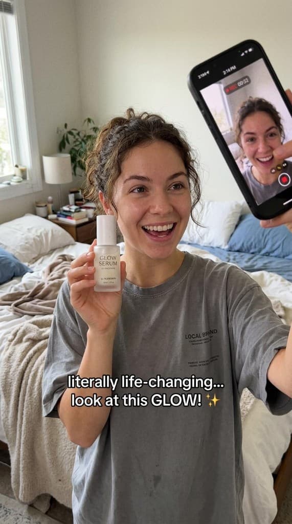 Product UGC ad example: creator holding a glow serum bottle while filming a phone-native vertical review